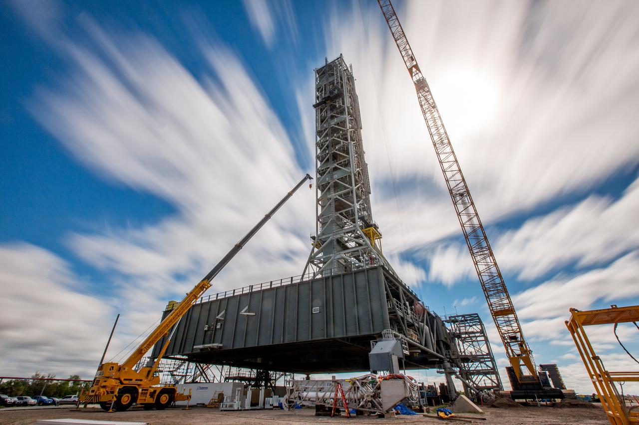 A long-exposure view of the mobile launcher at NASA's Kennedy Space Center in Florida. Cranes and rigging are being used to lift the bracket for the Orion Service Module Umbilical (OSMU) up for installation on the mobile launcher tower. The tower will be equipped with a number of lines, called umbilicals, that will connect to the Space Launch System rocket and Orion spacecraft for Exploration Mission-1 (EM-1). The OSMU will be located high on the mobile launcher tower and, prior to launch, will transfer liquid coolant for the electronics and air for the Environmental Control System to the Orion service module that houses these critical systems to support the spacecraft. EM-1 is scheduled to launch in 2018. The Ground Systems Development and Operations Program is overseeing installation of the umbilicals. 