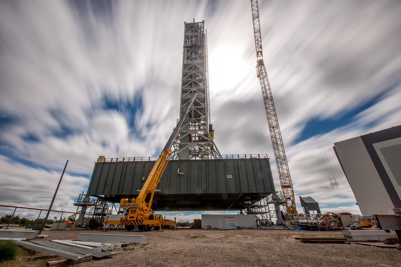 A long-exposure view of the mobile launcher at NASA's Kennedy Space Center in Florida. Cranes and rigging are being used to lift the bracket for the Orion Service Module Umbilical (OSMU) up for installation on the mobile launcher tower. The tower will be equipped with a number of lines, called umbilicals, that will connect to the Space Launch System rocket and Orion spacecraft for Exploration Mission-1 (EM-1). The OSMU will be located high on the mobile launcher tower and, prior to launch, will transfer liquid coolant for the electronics and air for the Environmental Control System to the Orion service module that houses these critical systems to support the spacecraft. EM-1 is scheduled to launch in 2018. The Ground Systems Development and Operations Program is overseeing installation of the umbilicals. 