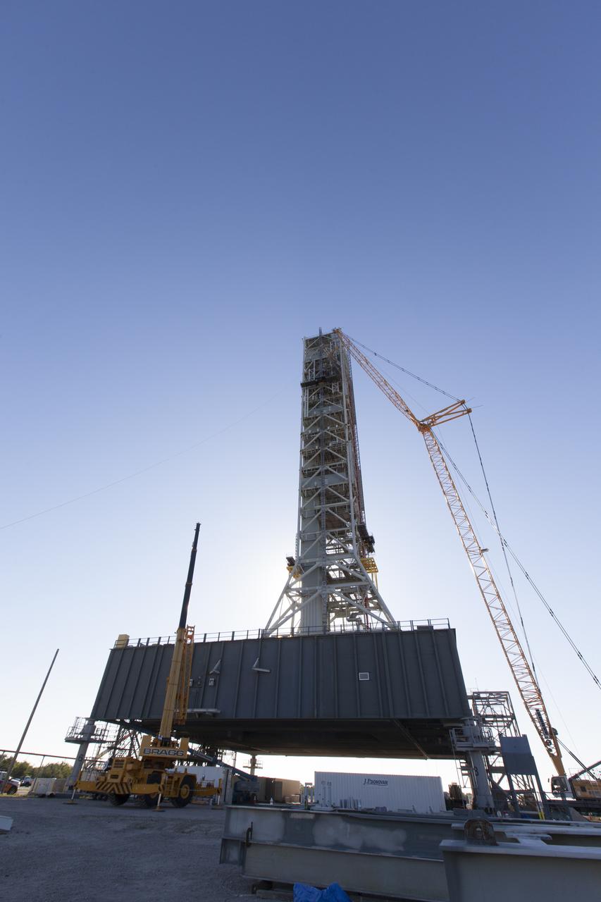 A crane and rigging are used to position the Orion Service Module Umbilical (OSMU) for installation high up on the mobile launcher tower at NASA's Kennedy Space Center in Florida. The mobile launcher tower will be equipped with a number of lines, called umbilicals, that will connect to the Space Launch System rocket and Orion spacecraft for Exploration Mission-1 (EM-1). The OSMU will be located high on the mobile launcher tower and, prior to launch, will transfer liquid coolant for the electronics and air for the Environmental Control System to the Orion service module that houses these critical systems to support the spacecraft. EM-1 is scheduled to launch in 2018. The Ground Systems Development and Operations Program is overseeing installation of the umbilicals. 