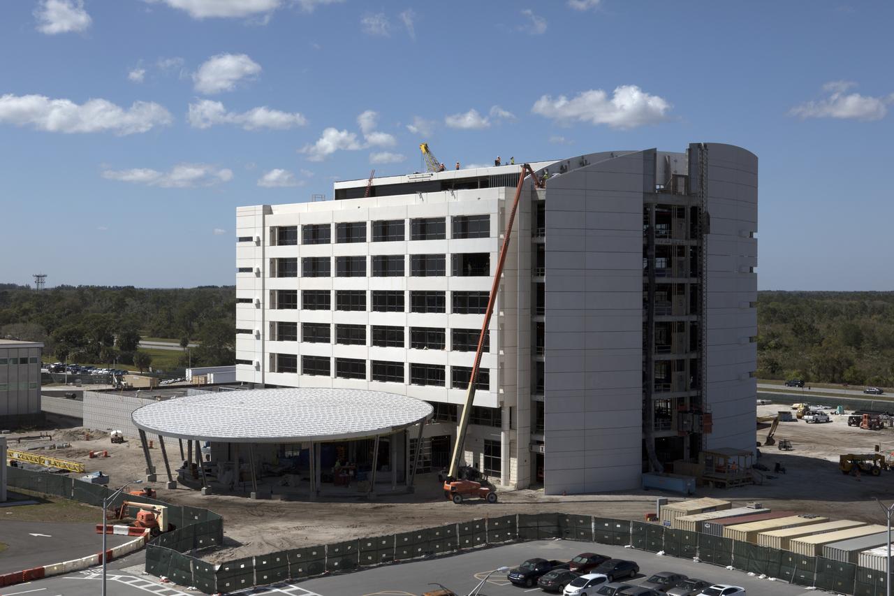 NASA's Kennedy Space Center in Florida is a premier, multi-user spaceport with ongoing construction adding new, ultra-modern facilities. A key element of the Central Campus makeover is a new, seven-story, 200,000-square-foot headquarters building that has taken shape in the heart of the spaceport. The headquarters building's glass facade, as seen from NASA Causeway, is complete. The exterior skin of the building also is nearly finished. The remainder of the glass components are being installed on each floor. Construction of interior walls and utilities on most floors is well underway. Construction of the headquarters building is targeted for completion in November 2017 and employees are expected to be able to move in soon after.