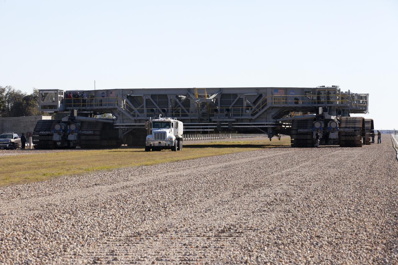 Crawler-transport 2 (CT-2) moves slowly along the crawlerway on its way back to the Vehicle Assembly Building at NASA's Kennedy Space Center in Florida. The crawler took a trip to the pad A/B split to test upgrades recently completed that will allow the giant vehicle to handle the load of the agency's Space Launch System rocket and Orion spacecraft atop the mobile launcher. The Ground Systems Development and Operations Program oversaw upgrades to the 50-year-old CT-2. New generators, gear assemblies, jacking, equalizing and leveling (JEL) hydraulic cylinders, roller bearings and brakes were installed, and other components were upgraded to prepare for Exploration Mission 1. 