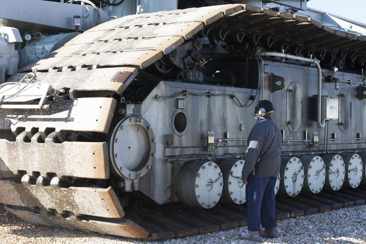 A ground support technician checks the giant treads on crawler-transporter 2 (CT-2) as the vehicle moves slowly along the crawlerway toward the Vehicle Assembly Building at NASA's Kennedy Space Center in Florida. The crawler took a trip to the pad A/B split to test upgrades recently completed that will allow the giant vehicle to handle the load of the agency's Space Launch System rocket and Orion spacecraft atop the mobile launcher. The Ground Systems Development and Operations Program oversaw upgrades to the 50-year-old CT-2. New generators, gear assemblies, jacking, equalizing and leveling (JEL) hydraulic cylinders, roller bearings and brakes were installed, and other components were upgraded to prepare for Exploration Mission 1.  