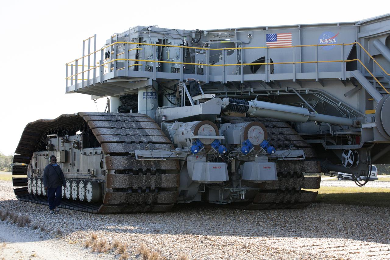 A ground support technician walks alongside crawler-transporter 2 (CT-2) as the vehicle moves slowly along the crawlerway toward the Vehicle Assembly Building at NASA's Kennedy Space Center in Florida. The crawler took a trip to the Pad A/B split to test upgrades recently completed that will allow the giant vehicle to handle the load of the agency's Space Launch System rocket and Orion spacecraft atop the mobile launcher. The Ground Systems Development and Operations Program oversaw upgrades to the 50-year-old CT-2. New generators, gear assemblies, jacking, equalizing and leveling (JEL) hydraulic cylinders, roller bearings and brakes were installed, and other components were upgraded to prepare for Exploration Mission 1.  