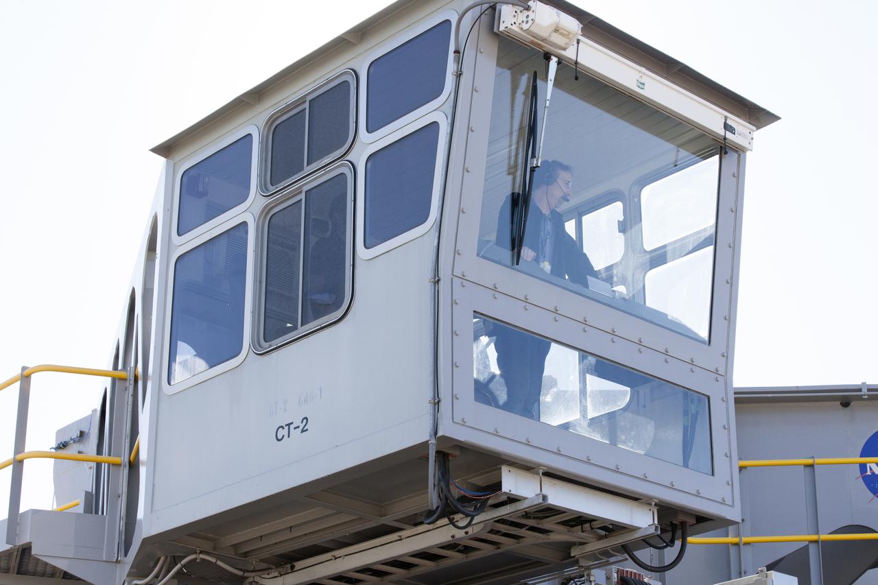 Brad Lawarre, a crawler engineer and driver on the Test and Operations Support Contract, monitors the progress from one of the crawler-transporter 2 (CT-2) cabs as the vehicle moves slowly along the crawlerway toward the Vehicle Assembly Building at NASA's Kennedy Space Center Florida. The crawler took a trip to the Pad A/B split to test upgrades recently completed that will allow the giant vehicle to handle the load of the agency's Space Launch System rocket and Orion spacecraft atop the mobile launcher. The Ground Systems Development and Operations Program oversaw upgrades to the 50-year-old CT-2. New generators, gear assemblies, jacking, equalizing and leveling (JEL) hydraulic cylinders, roller bearings and brakes were installed, and other components were upgraded to prepare for Exploration Mission 1.  