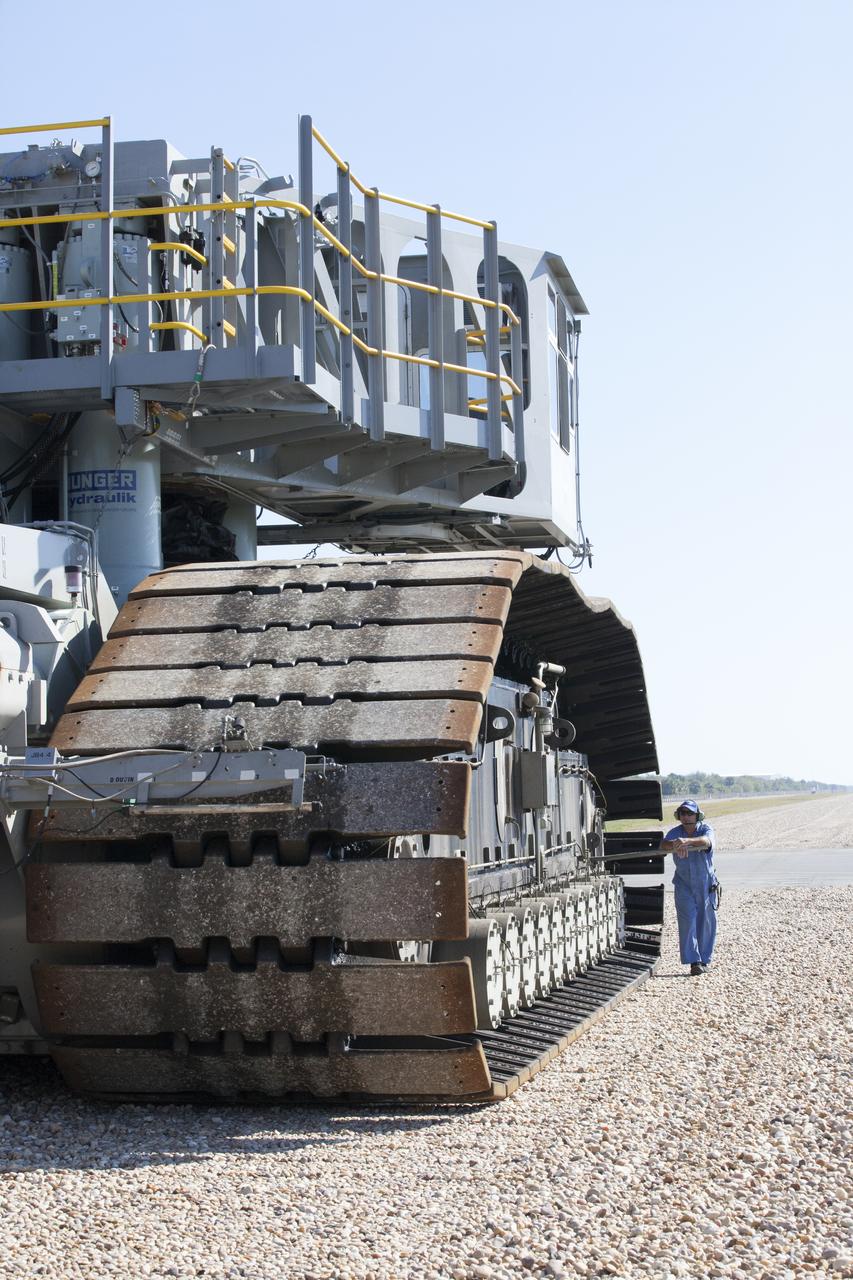 A ground support technician walks alongside crawler-transporter 2 (CT-2) as the vehicle moves slowly along the crawlerway toward the Vehicle Assembly Building at NASA's Kennedy Space Center in Florida. The crawler took a trip to the Pad A/B split to test upgrades recently completed that will allow the giant vehicle to handle the load of the agency's Space Launch System rocket and Orion spacecraft atop the mobile launcher. The Ground Systems Development and Operations Program oversaw upgrades to the 50-year-old CT-2. New generators, gear assemblies, jacking, equalizing and leveling (JEL) hydraulic cylinders, roller bearings and brakes were installed, and other components were upgraded to prepare for Exploration Mission 1.  