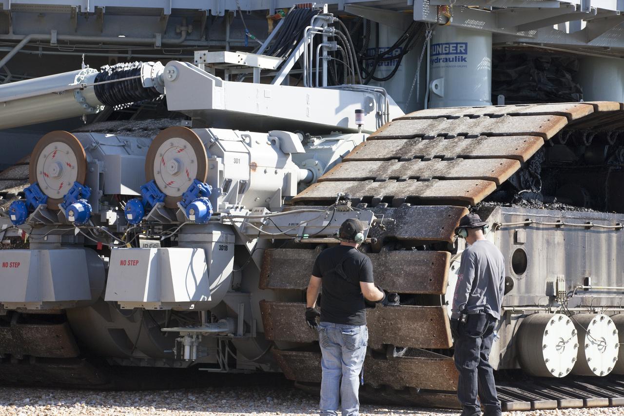 Ground support technicians check out the treads on crawler-transporter 2 (CT-2) as the vehicle moves slowly along the crawlerway toward the Vehicle Assembly Building at NASA's Kennedy Space Center in Florida. The crawler took a trip to the Pad A/B split to test upgrades recently completed that will allow the giant vehicle to handle the load of the agency's Space Launch System rocket and Orion spacecraft atop the mobile launcher. The Ground Systems Development and Operations Program oversaw upgrades to the 50-year-old CT-2. New generators, gear assemblies, jacking, equalizing and leveling (JEL) hydraulic cylinders, roller bearings and brakes were installed, and other components were upgraded to prepare for Exploration Mission 1.  
