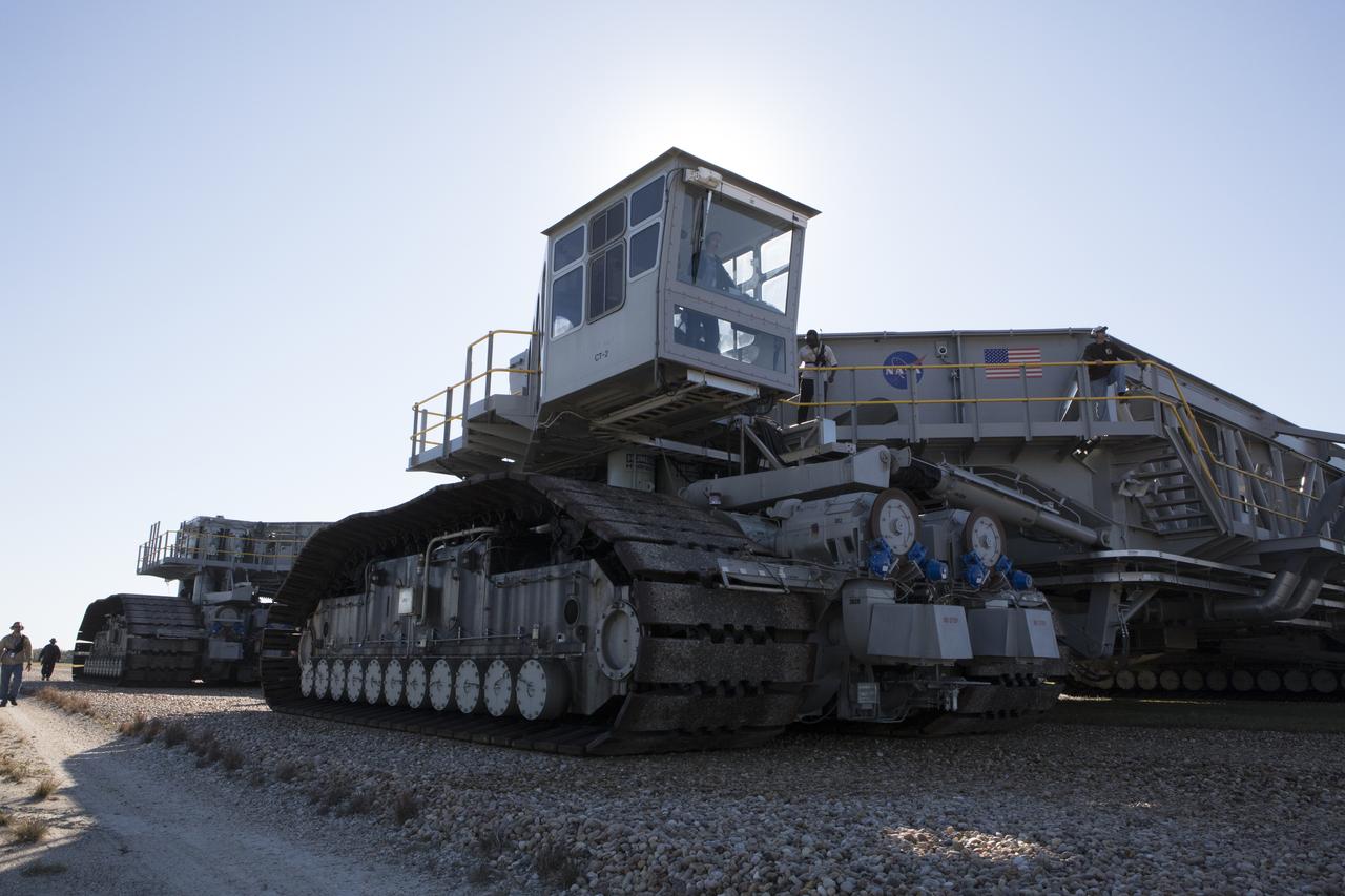 Ground support technicians walks alongside crawler-transporter 2 (CT-2) as the vehicle moves slowly along the crawlerway toward the Vehicle Assembly Building at NASA's Kennedy Space Center in Florida. The crawler took a trip to the Pad A/B split to test upgrades recently completed that will allow the giant vehicle to handle the load of the agency's Space Launch System rocket and Orion spacecraft atop the mobile launcher. The Ground Systems Development and Operations Program oversaw upgrades to the 50-year-old CT-2. New generators, gear assemblies, jacking, equalizing and leveling (JEL) hydraulic cylinders, roller bearings and brakes were installed, and other components were upgraded to prepare for Exploration Mission 1.  