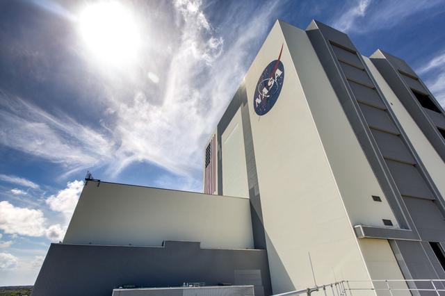 A long exposure photograph of the Vehicle Assembly Building, against the backdrop of a bright blue sky, at NASA's Kennedy Space Center in Florida. Inside the VAB, 10 levels of platforms, 20 platform halves altogether, have been installed in High Bay 3. The platforms will surround NASA's Space Launch System (SLS) rocket and the Orion spacecraft and allow access during processing for missions, including the first uncrewed flight test of Orion atop the SLS rocket in 2018. The Ground Systems Development and Operations Program, along with center's Engineering Directorate, is overseeing upgrades and modifications to the VAB to support the multi-user spaceport.