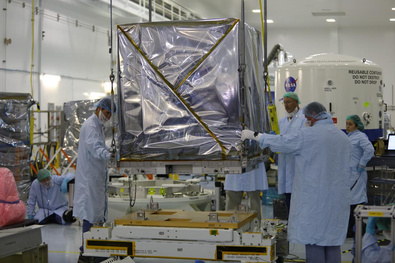 Inside the Space Station Processing Facility high bay at NASA's Kennedy Space Center in Florida, technicians assist as a crane is used to lift the Neutron star Interior Composition Explorer, or NICER, payload up from its carrier. NICER will be delivered to the International Space Station aboard the SpaceX Dragon cargo carrier on the company’s 11th commercial resupply services mission to the space station. NICER will study neutron stars through soft X-ray timing. NICER will enable rotation-resolved spectroscopy of the thermal and non-thermal emissions of neutron stars in the soft X-ray band with unprecedented sensitivity, probing interior structure, the origins of dynamic phenomena and the mechanisms that underlie the most powerful cosmic particle accelerators known. 