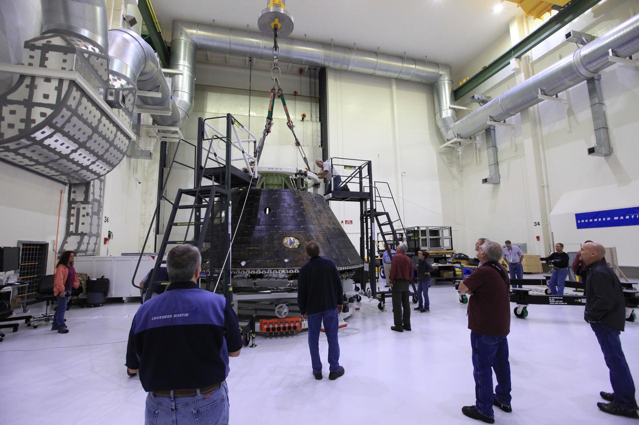 Inside the Neil Armstrong Operations and Checkout Building high bay at NASA's Kennedy Space Center in Florida, Lockheed Martin and ASRC workers monitor the progress as a crane is attached to the top of the Orion crew module from Exploration Flight Test 1. The crew module will be moved to the nearby Kennedy Space Center Visitor Complex and delivered to the IMAX Theater where it will be prepared for display in the NASA Now exhibit. The Orion spacecraft launched atop a United Launch Alliance Delta IV rocket Dec. 5, 2014, from Space Launch Complex 37 at Cape Canaveral Air Force Station. The spacecraft built for humans traveled 3,604 miles above Earth and splashed down about 4.5 hours later in the Pacific Ocean. 