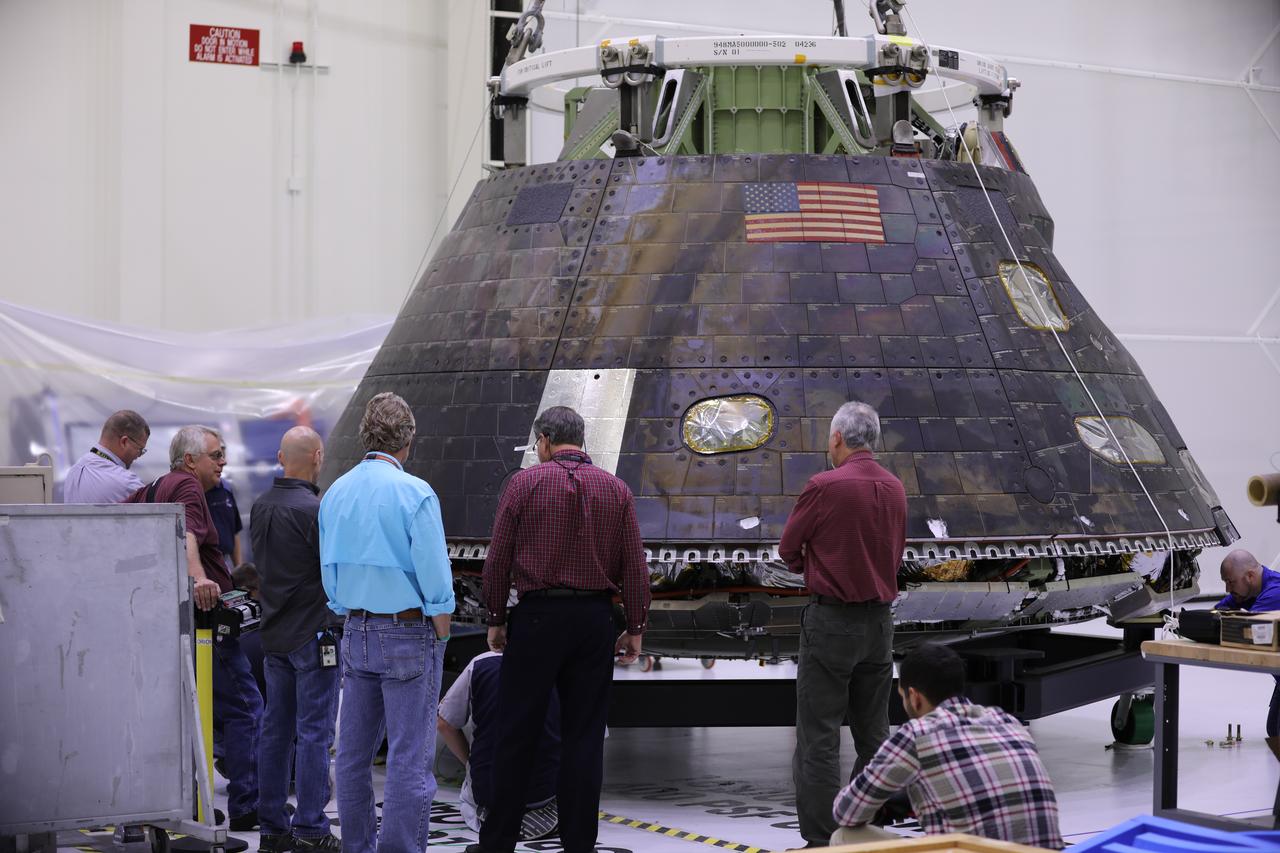 Inside the Neil Armstrong Operations and Checkout Building high bay at NASA's Kennedy Space Center in Florida, the Orion crew module from Exploration Flight Test 1 is lowered onto a custom-built transport stand. The crew module is being prepared for its move to the nearby Kennedy Space Center Visitor Complex and delivery to the IMAX Theater where it will be on display in the NASA Now exhibit. The Orion spacecraft launched atop a United Launch Alliance Delta IV rocket Dec. 5, 2014, from Space Launch Complex 37 at Cape Canaveral Air Force Station. The spacecraft built for humans traveled 3,604 miles above Earth and splashed down about 4.5 hours later in the Pacific Ocean. 