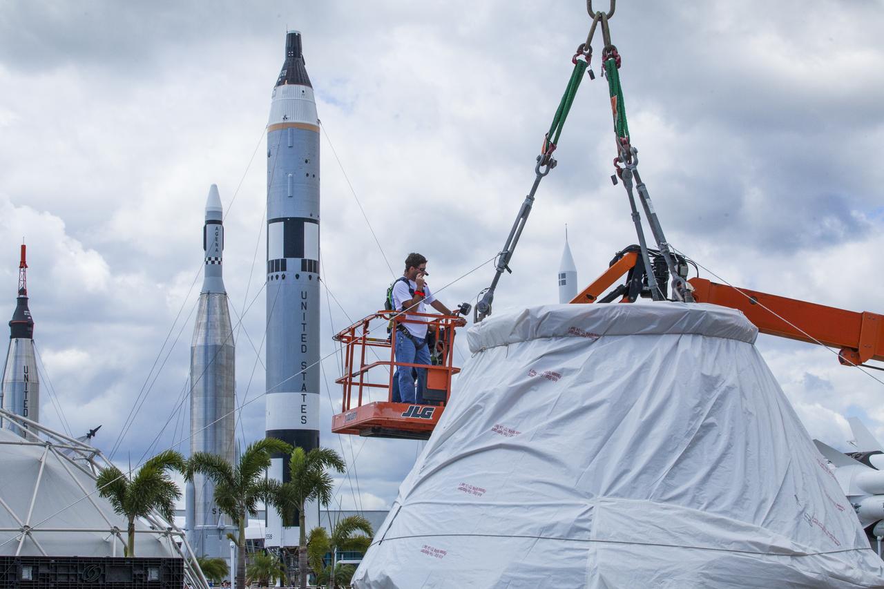 At NASA's Kennedy Space Center Visitor Complex in Florida, a crane is attached to the Orion crew module from Exploration Flight Test 1 secured on its custom-made ground support equipment. The crew module will be delivered to the IMAX Theater where it will be prepared for display in the NASA Now exhibit. The Orion spacecraft launched atop a United Launch Alliance Delta IV rocket Dec. 5, 2014, from Space Launch Complex 37 at Cape Canaveral Air Force Station. The spacecraft built for humans traveled 3,604 miles above Earth and splashed down about 4.5 hours later in the Pacific Ocean. 
