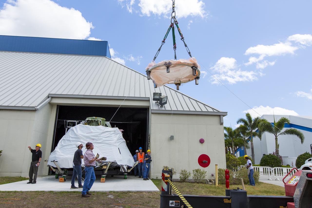 At the IMAX Theater at NASA's Kennedy Space Center Visitor Complex in Florida, the Orion crew module from Exploration Flight Test 1, secured on its custom-made ground support equipment, has been lowered to the ground. The crew module will be moved inside the theater where it will be prepared for display in the NASA Now exhibit. The Orion spacecraft launched atop a United Launch Alliance Delta IV rocket Dec. 5, 2014, from Space Launch Complex 37 at Cape Canaveral Air Force Station. The spacecraft built for humans traveled 3,604 miles above Earth and splashed down about 4.5 hours later in the Pacific Ocean. 