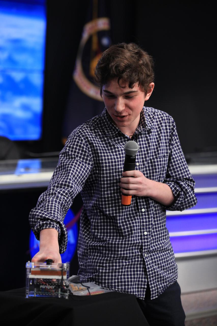 Julian Rubinfien, student Genes in Space II winner, explains his experiment during a "What's on Board" science briefing to NASA Social participants at the agency's Kennedy Space Center in Florida. The briefing was for Orbital ATK's seventh commercial resupply services mission, CRS-7, to the International Space Station. Orbital ATK's Cygnus pressurized cargo module is set to launch on the United Launch Alliance Atlas V rocket from Space Launch Complex 41 at Cape Canaveral Air Force Station on April 18. Liftoff is scheduled for 11:11 a.m. EDT.  