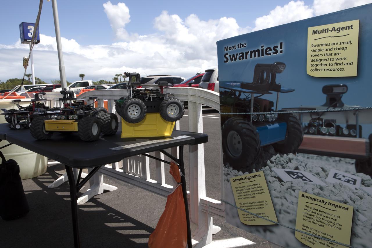 A display at the Kennedy Space Center Visitor Complex describes the purpose of Swarmies. Computer scientists are developing these robots focusing not so much on the hardware, but the software. In the spaceport's annual Swarmathon, students from 12 colleges and universities across the nation were invited to develop software code to operate Swarmies to help find resources when astronauts explore distant planets, such as Mars.