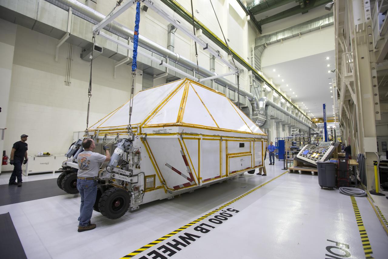 Inside the Neil Armstrong Operations and Checkout Building high bay at NASA's Kennedy Space Center in Florida, the Orion Exploration Mission-1 (EM-1) structural test article is secured inside its transport container. A crane is used to move the container toward a transport vehicle for the move to the Shuttle Landing Facility. The test article will be loaded in NASA's Super Guppy airplane and transported to Lockheed Martin's Denver facility for testing. The Orion spacecraft will launch atop NASA’s Space Launch System rocket on EM-1, its first deep space mission.