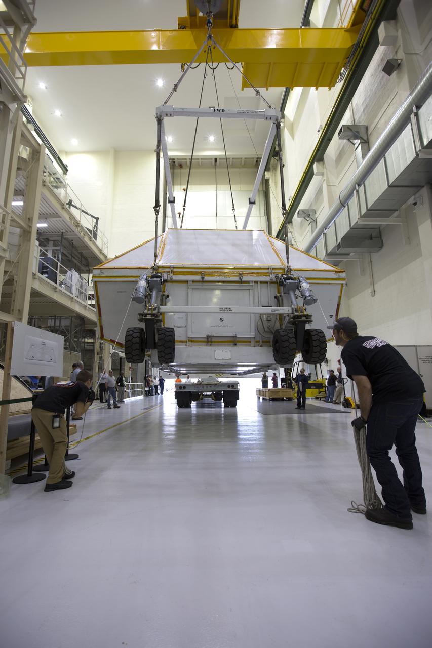 Inside the Neil Armstrong Operations and Checkout Building high bay at NASA's Kennedy Space Center in Florida, the Orion Exploration Mission-1 (EM-1) structural test article is secured inside its transport container. Technicians monitor the progress as a crane is used to move the container toward a transport vehicle for the move to the Shuttle Landing Facility. The test article will be loaded in NASA's Super Guppy airplane and transported to Lockheed Martin's Denver facility for testing. The Orion spacecraft will launch atop NASA’s Space Launch System rocket on EM-1, its first deep space mission. 