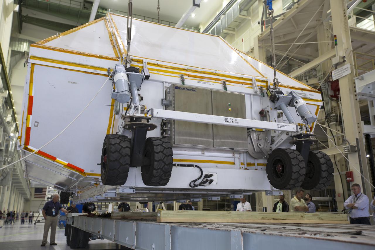 Inside the Neil Armstrong Operations and Checkout Building high bay at NASA's Kennedy Space Center in Florida, the Orion Exploration Mission-1 (EM-1) structural test article, secured inside its transport container, is lowered onto a transport vehicle for the move to the Shuttle Landing Facility. The test article will be loaded in NASA's Super Guppy airplane and transported to Lockheed Martin's Denver facility for testing. The Orion spacecraft will launch atop NASA’s Space Launch System rocket on EM-1, its first deep space mission.