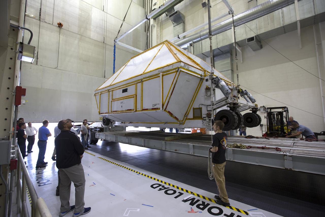 Inside the Neil Armstrong Operations and Checkout Building high bay at NASA's Kennedy Space Center in Florida, the Orion Exploration Mission-1 (EM-1) structural test article, secured inside its transport container, is lowered onto a transport vehicle for the move to the Shuttle Landing Facility. The test article will be loaded in NASA's Super Guppy airplane and transported to Lockheed Martin's Denver facility for testing. The Orion spacecraft will launch atop NASA’s Space Launch System rocket on EM-1, its first deep space mission.