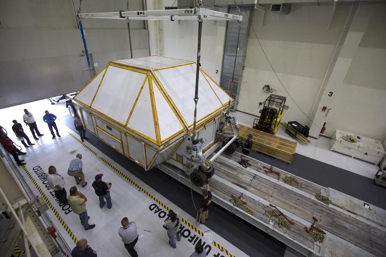 Inside the Neil Armstrong Operations and Checkout Building high bay at NASA's Kennedy Space Center in Florida, the Orion Exploration Mission-1 (EM-1) structural test article inside its transport container, is secured onto a transport vehicle for the move to the Shuttle Landing Facility. The test article will be loaded in NASA's Super Guppy airplane and transported to Lockheed Martin's Denver facility for testing. The Orion spacecraft will launch atop NASA’s Space Launch System rocket on EM-1, its first deep space mission.
