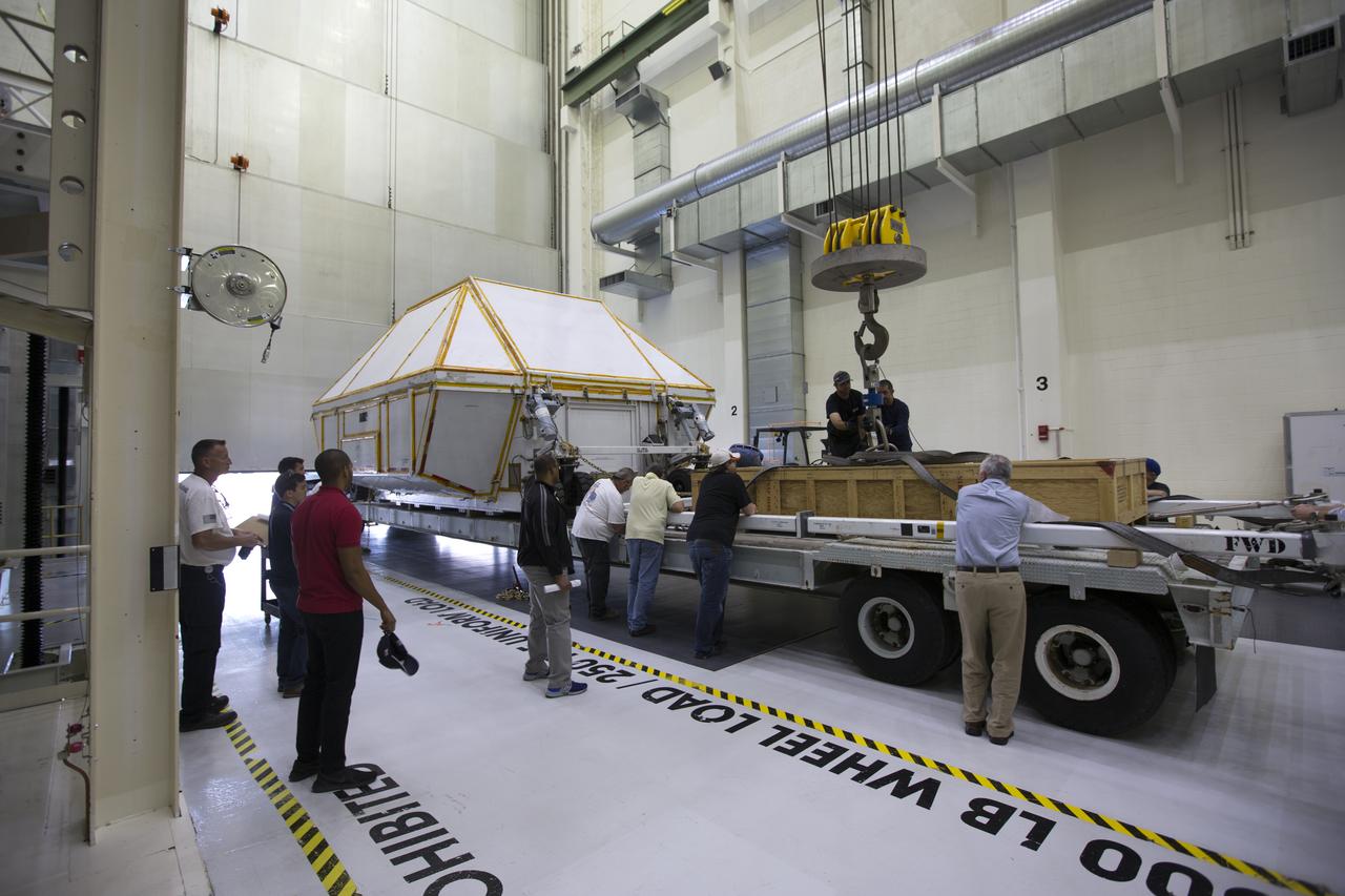 Inside the Neil Armstrong Operations and Checkout Building high bay at NASA's Kennedy Space Center in Florida, technicians secure the transport container with the Orion Exploration Mission-1 (EM-1) structural test article onto a transport vehicle for the move to the Shuttle Landing Facility. The test article will be loaded in NASA's Super Guppy airplane and transported to Lockheed Martin's Denver facility for testing. The Orion spacecraft will launch atop NASA’s Space Launch System rocket on EM-1, its first deep space mission. 