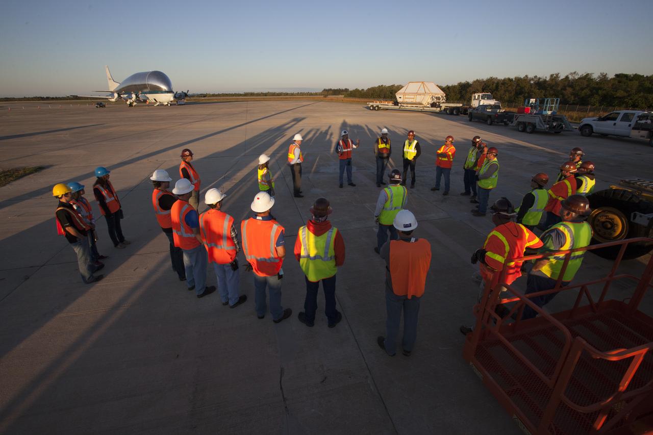 On the tarmac at the Shuttle Landing Facility at NASA's Kennedy Space Center in Florida, NASA and contractor workers review procedures before beginning loading of the Orion Exploration Mission-1 (EM-1) structural test article in its transport container into NASA's Super Guppy aircraft. The test article will be transported to Lockheed Martin's Denver facility for testing. The Orion spacecraft will launch atop NASA’s Space Launch System rocket on EM-1, its first deep space mission. 