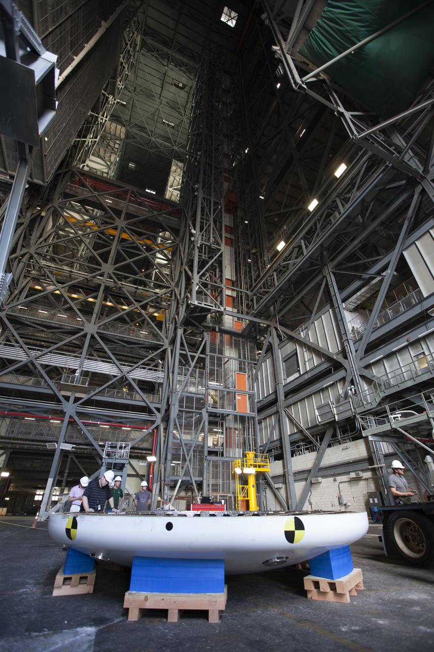 Inside High Bay 2 in the Vehicle Assembly Building (VAB) at NASA's Kennedy Space Center in Florida, the Orion heat shield from Exploration Flight Test-1 is secured on foam blocks. The heat shield is being transferred from the Orion Program to the Ground Systems Development and Operations Program, Landing and Recovery Operations. In the VAB, the heat shield will be integrated with the Orion ground test article and used for future underway recovery testing. 
