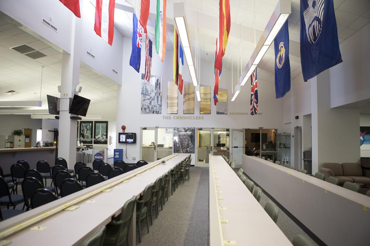 Brass plaques engraved with the names of "The Chroniclers" adorn the wall at the NASA News Center at Kennedy Space Center in Florida. In the foreground are rows of stations where reporters from television, radio, print and online media outlets have monitored countless launches, landings and other space events in order to deliver the news to the world. The Chroniclers program recognizes retirees of the news and communications business who helped spread news of American space exploration from Kennedy Space Center for ten years or more.