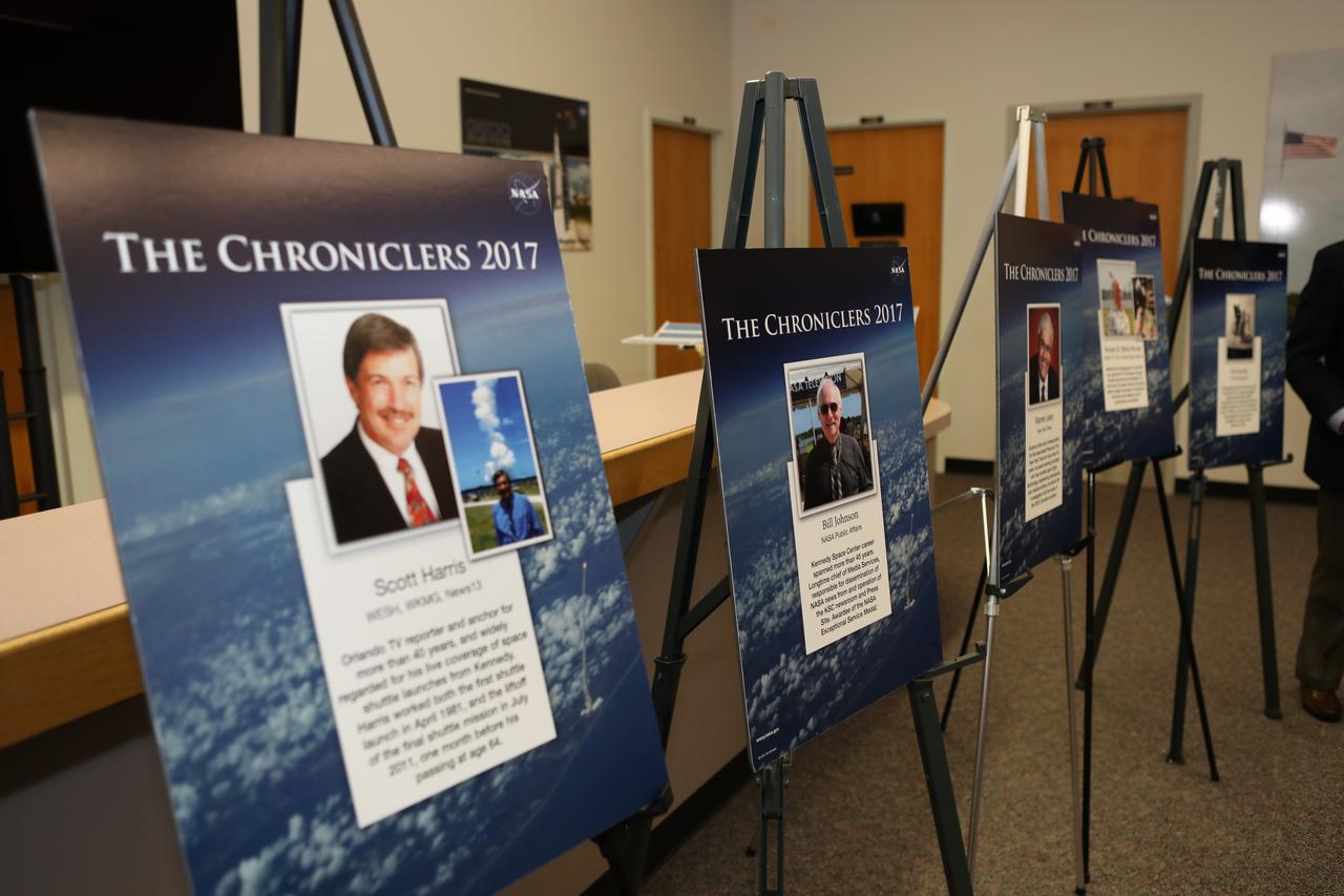 Posters in the NASA News Center at Kennedy Space Center in Florida bear the names and photos of five of the six new honorees added to the facility's "Chroniclers" roll of honor. From left to right are posters featuring Scott Harris, WESH, WKMG and Central Florida News 13; Bill Johnson, NASA Public Affairs; Warren Leary, The New York Times; Bob Murray, WDBO-TV, RCA and United Space Alliance; and Phillip Sandlin, Associated Press photographer. Not pictured is the poster for Bruce Hall, CBS News and NBC News. The Chroniclers program recognizes retirees of the news and communications business who helped spread news of American space exploration from Kennedy Space Center for ten years or more. 