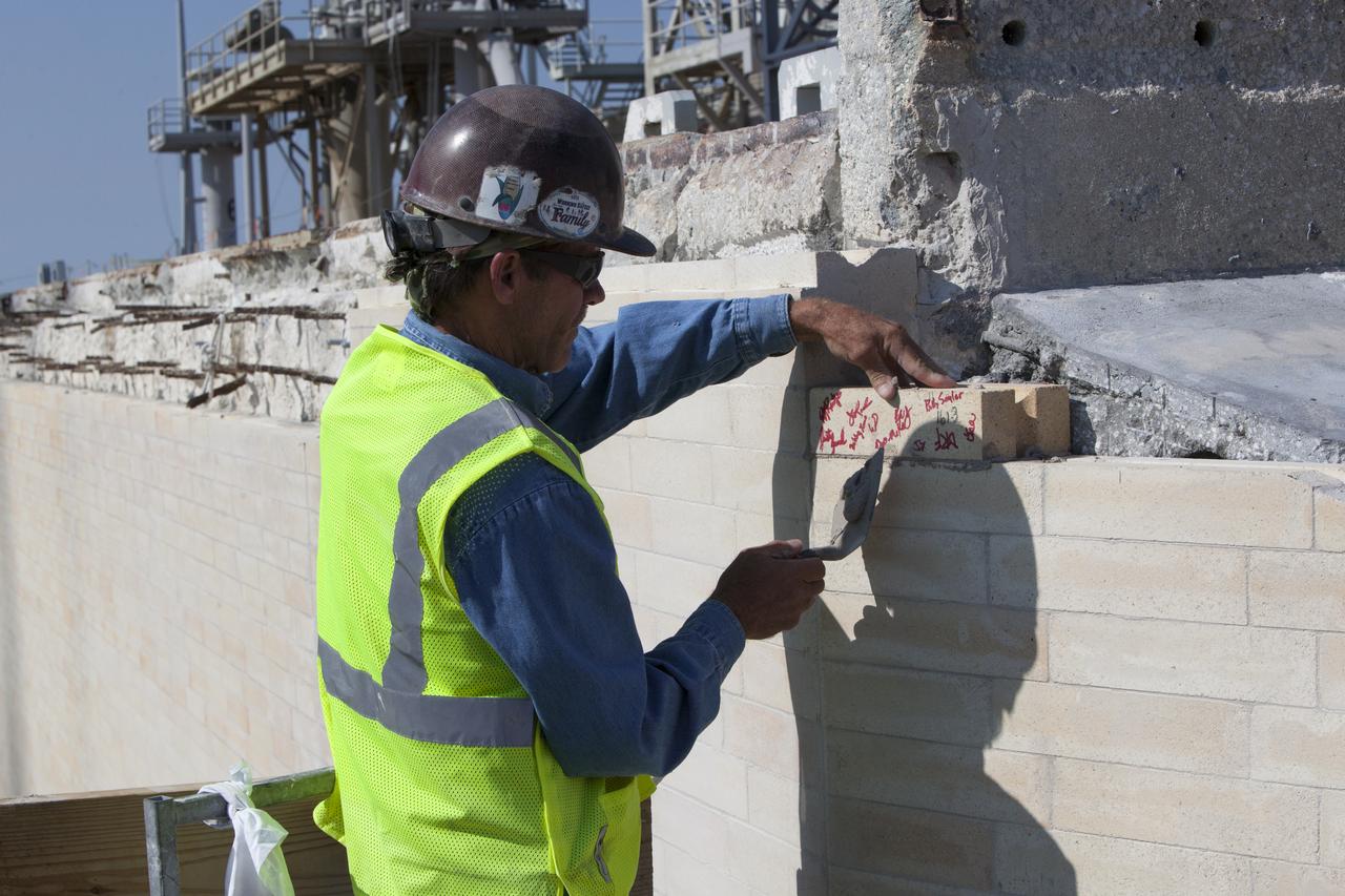A construction worker installs one of the final bricks on the north side of the flame trench at Launch Complex 39B at NASA's Kennedy Space Center in Florida. The walls of the flame trench are being upgraded to withstand the intense heat and fire at launch of NASA's Space Launch System rocket with Orion atop. About 96,000 heat-resistant bricks, in three different sizes, were secured to the walls using bonding mortar in combination with adhesive anchors. The Ground Systems Development and Operations Program is overseeing upgrades and modifications to Pad 39B to support the launch of the SLS and Orion spacecraft for Exploration Mission-1 and NASA’s journey to Mars.