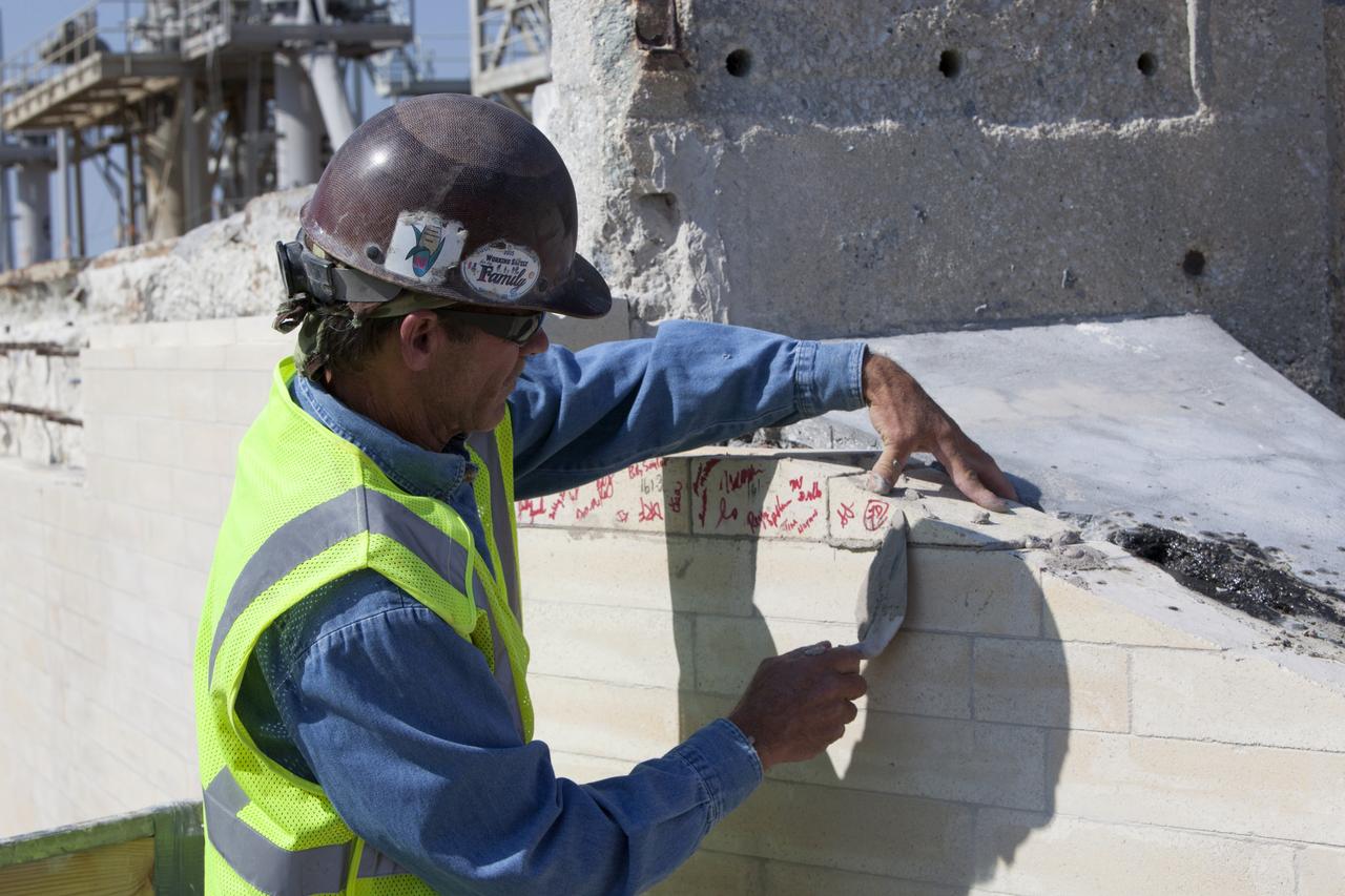 A construction worker installs the final brick on the north side of the flame trench at Launch Complex 39B at NASA's Kennedy Space Center in Florida. The walls of the flame trench are being upgraded to withstand the intense heat and fire at launch of NASA's Space Launch System rocket with Orion atop. About 96,000 heat-resistant bricks, in three different sizes, were secured to the walls using bonding mortar in combination with adhesive anchors. The Ground Systems Development and Operations Program is overseeing upgrades and modifications to Pad 39B to support the launch of the SLS and Orion spacecraft for Exploration Mission-1 and NASA’s journey to Mars.