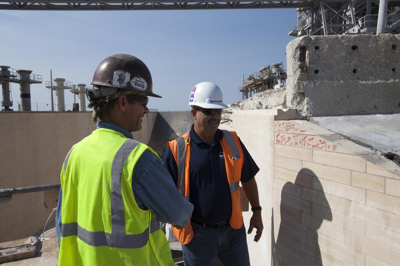 Construction workers sign the final bricks after they were installed on the north side of the flame trench at Launch Complex 39B at NASA’s Kennedy Space Center in Florida. The walls of the flame trench are being upgraded to withstand the intense heat and fire at launch of NASA's Space Launch System rocket with Orion atop. About 96,000 heat-resistant bricks, in three different sizes, were secured to the walls using bonding mortar in combination with adhesive anchors. The Ground Systems Development and Operations Program is overseeing upgrades and modifications to Pad 39B to support the launch of the SLS and Orion spacecraft for Exploration Mission-1 and NASA’s journey to Mars.