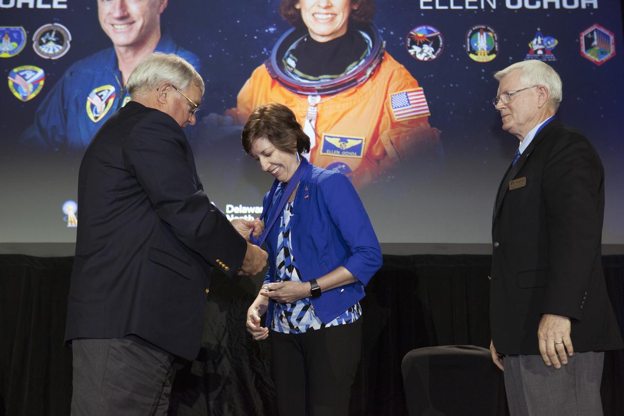 In the Space Shuttle Atlantis facility at the Kennedy Space Center Visitor Complex in Florida, Astronaut Scholarship Foundation Chairman Dan Brandenstein, left, also a Hall of Fame astronaut, presents inductee Ellen Ochoa with her hall of fame medal. Former Johnson Space Center Director Mike Coats, right, a Hall of Fame member, presented Ochoa for induction. During this year's ceremonies, space shuttle astronaut Michael Foale also was enshrined.