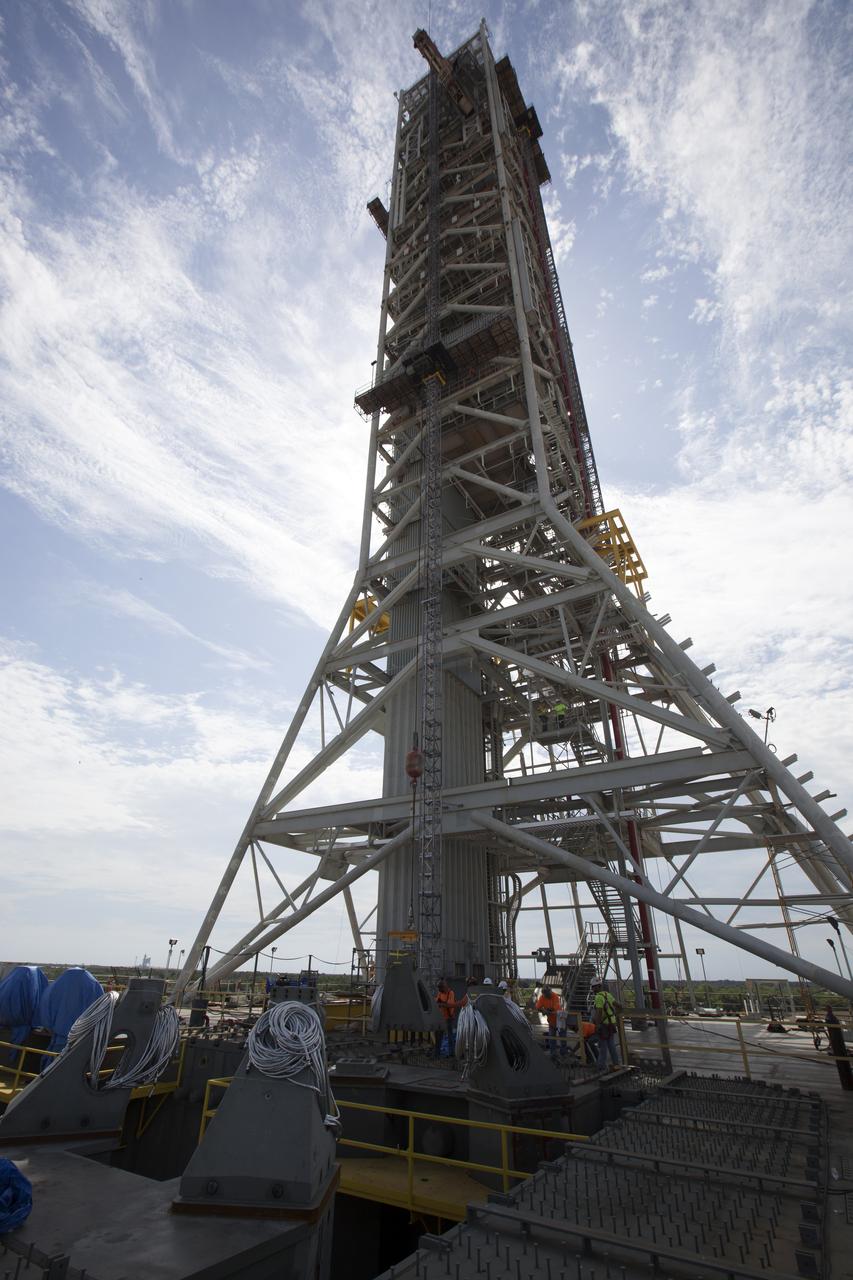 Construction workers on the deck of the mobile launcher at NASA's Kennedy Space Center in Florida, prepare to install a vehicle support post. A total of eight support posts are being installed to support the load of the Space Launch System's (SLS) solid rocket boosters, with four posts for each of the boosters. The support posts are about five feet tall and each weigh about 10,000 pounds. The posts will structurally support the SLS rocket through T-0 and liftoff, and will drop down before vehicle liftoff to avoid contact with the flight hardware. The Ground Systems Development and Operations Program is overseeing installation of the support posts to prepare for the launch of the Orion spacecraft atop the SLS rocket. 