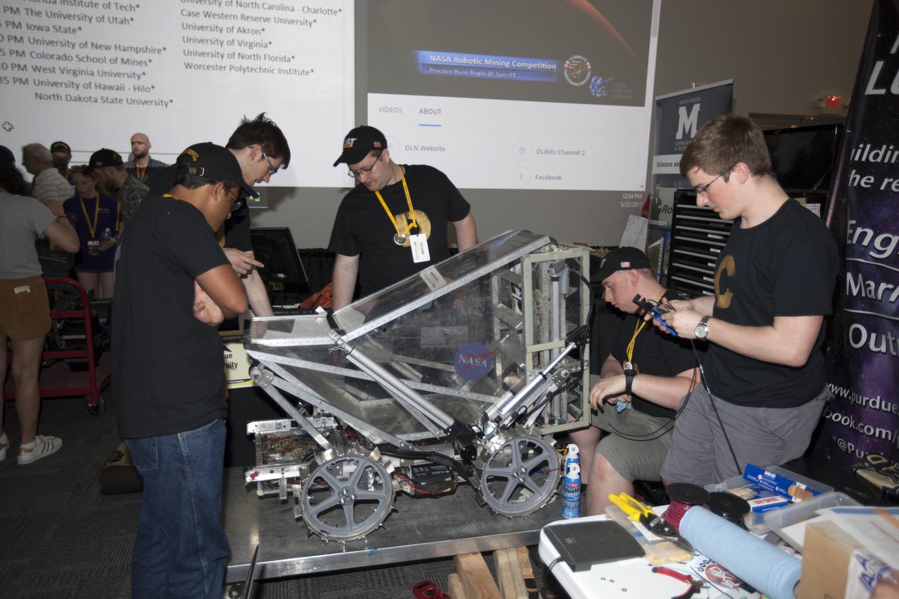 Team members from Purdue University prepare their uniquely-designed robot miner in the RoboPit at NASA's 8th Annual Robotic Mining Competition at the Kennedy Space Center Visitor Complex in Florida. More than 40 student teams from colleges and universities around the U.S. will use their uniquely-designed mining robots to dig in a supersized sandbox filled with BP-1, or simulated Martian soil, and participate in other competition requirements. The Robotic Mining Competition is a NASA Human Exploration and Operations Mission Directorate project designed to encourage students in science, technology, engineering and math, or STEM fields. The project provides a competitive environment to foster innovative ideas and solutions that could be used on NASA's Journey to Mars. 