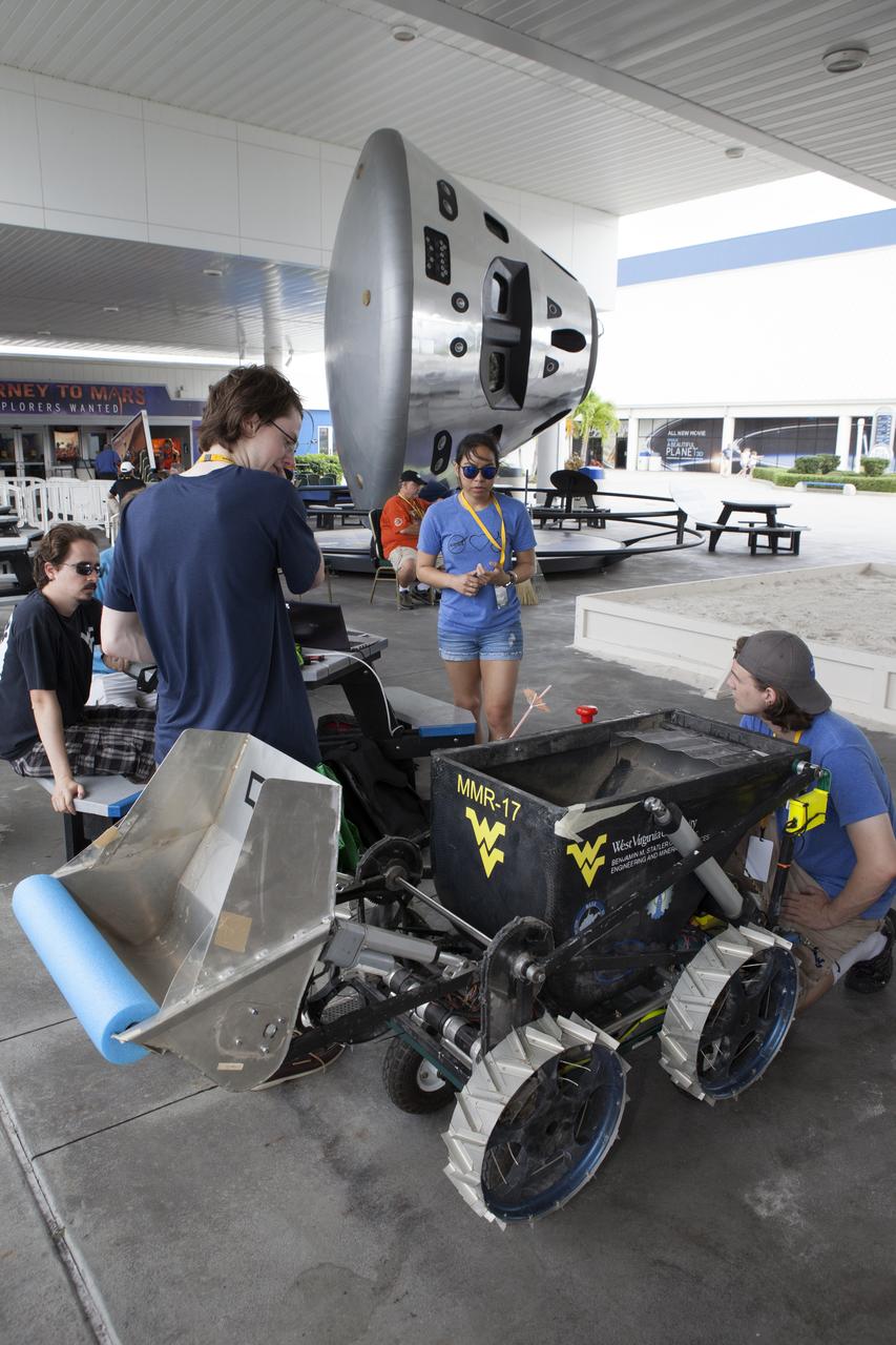 Team members from West Virginia University prepare their mining robot for a test run in a giant sandbox before their scheduled mining run in the arena during NASA's 8th Annual Robotic Mining Competition at the Kennedy Space Center Visitor Complex in Florida. More than 40 student teams from colleges and universities around the U.S. are using their uniquely-designed mining robots to dig in a supersized sandbox filled with BP-1, or simulated Martian soil, and participate in other competition requirements. The Robotic Mining Competition is a NASA Human Exploration and Operations Mission Directorate project designed to encourage students in science, technology, engineering and math, or STEM fields. The project provides a competitive environment to foster innovative ideas and solutions that could be used on NASA's Journey to Mars. 