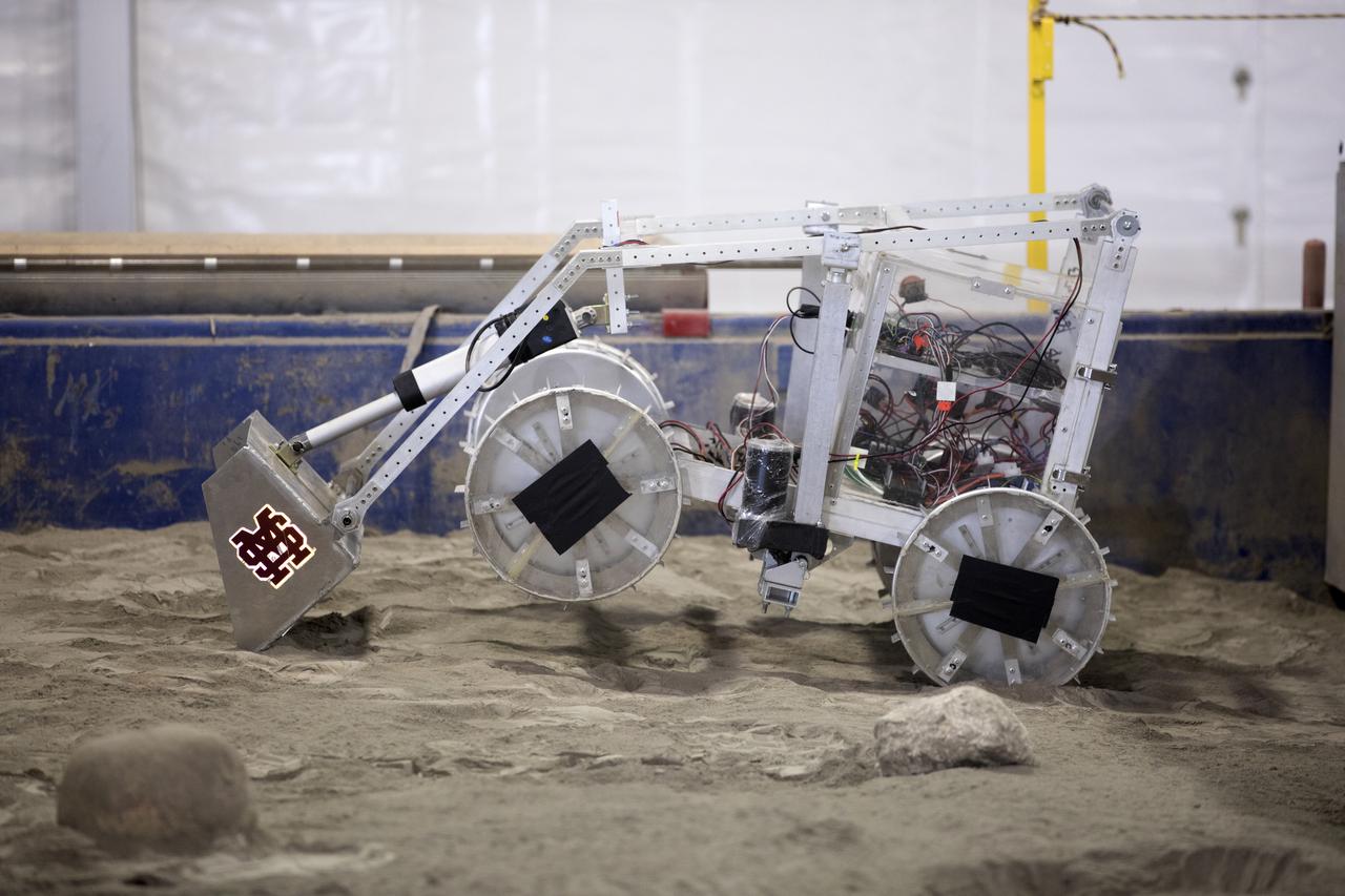 The robotic miner from Mississippi State University digs in the mining arena during NASA's 8th Annual Robotic Mining Competition at the Kennedy Space Center Visitor Complex in Florida. More than 40 student teams from colleges and universities around the U.S. are using their uniquely-designed mining robots to dig in a supersized sandbox filled with BP-1, or simulated Martian soil, and participate in other competition requirements. The Robotic Mining Competition is a NASA Human Exploration and Operations Mission Directorate project designed to encourage students in science, technology, engineering and math, or STEM fields. The project provides a competitive environment to foster innovative ideas and solutions that could be used on NASA's Journey to Mars. 