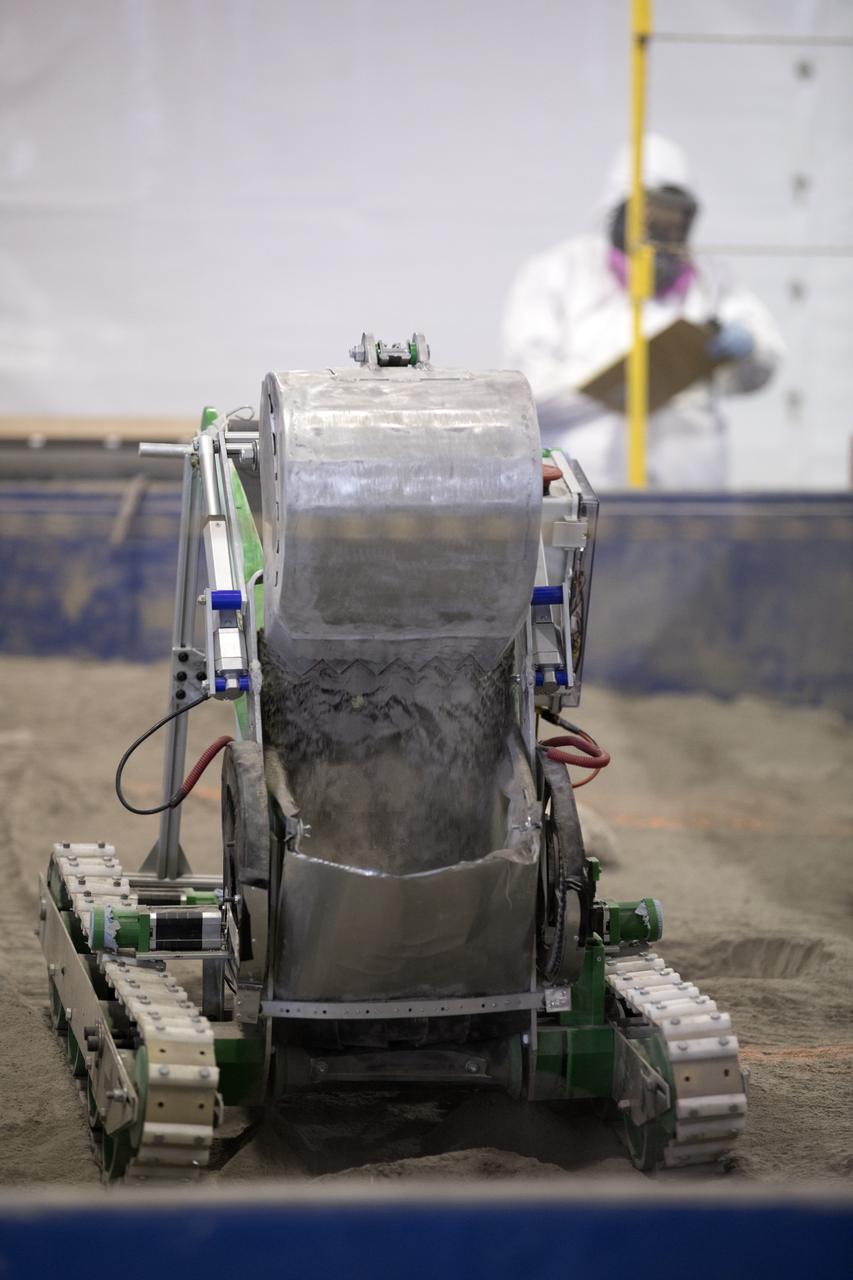 A robotic miner digs in the mining arena during NASA's 8th Annual Robotic Mining Competition at the Kennedy Space Center Visitor Complex in Florida. More than 40 student teams from colleges and universities around the U.S. are using their uniquely-designed mining robots to dig in a supersized sandbox filled with BP-1, or simulated Martian soil, and participate in other competition requirements. The Robotic Mining Competition is a NASA Human Exploration and Operations Mission Directorate project designed to encourage students in science, technology, engineering and math, or STEM fields. The project provides a competitive environment to foster innovative ideas and solutions that could be used on NASA's Journey to Mars.
