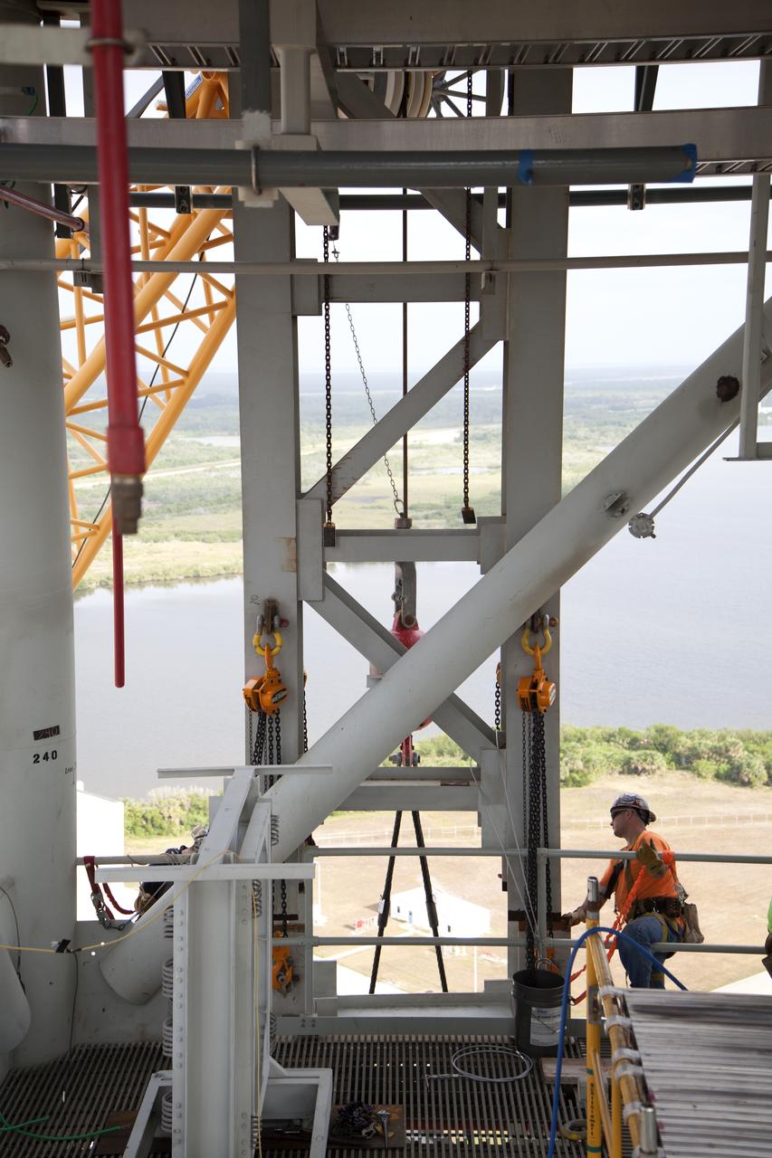 Construction workers assist as a crane lifts the Core Stage Forward Skirt Umbilical up for installation on the mobile launcher tower at NASA's Kennedy Space Center in Florida. The mobile launcher tower will be equipped with a number of lines, called umbilicals that will connect to the Space Launch System (SLS) rocket and Orion spacecraft for Exploration Mission-1 (EM-1). The CSFSU will be located at about the 180-foot level on the tower, above the liquid oxygen tank. The CSFSU is an umbilical that will swing into position to provide connections to the core stage forward skirt of the SLS rocket, and then swing away before launch. Its main purpose is to provide conditioned air/GN2 to the SLS core stage forward skirt cavity. The Ground Systems Development and Operations Program is overseeing installation of the umbilicals. 