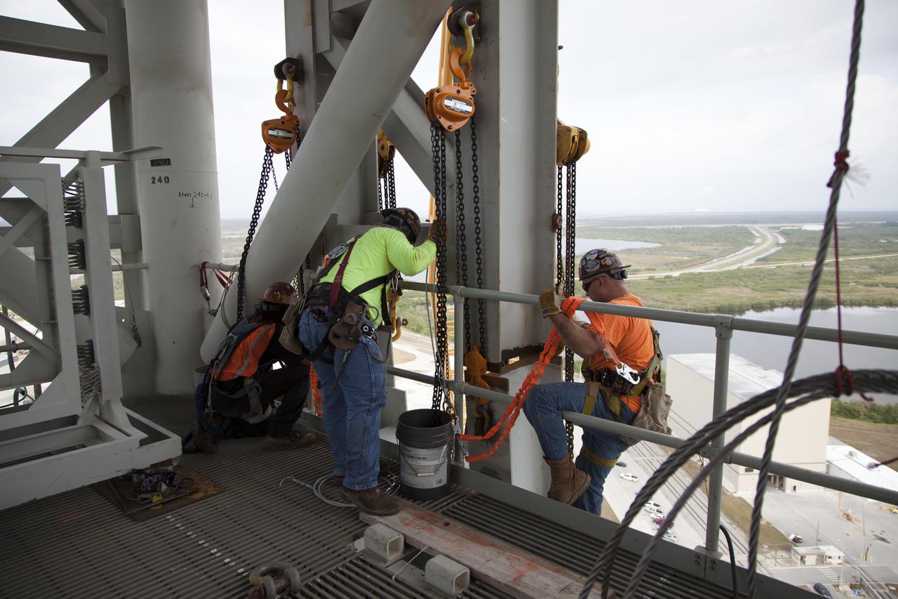 Construction workers assist as a crane lifts the Core Stage Forward Skirt Umbilical up for installation on the mobile launcher tower at NASA's Kennedy Space Center in Florida. The mobile launcher tower will be equipped with a number of lines, called umbilicals that will connect to the Space Launch System (SLS) rocket and Orion spacecraft for Exploration Mission-1 (EM-1). The CSFSU will be located at about the 180-foot level on the tower, above the liquid oxygen tank. The CSFSU is an umbilical that will swing into position to provide connections to the core stage forward skirt of the SLS rocket, and then swing away before launch. Its main purpose is to provide conditioned air/GN2 to the SLS core stage forward skirt cavity. The Ground Systems Development and Operations Program is overseeing installation of the umbilicals. 