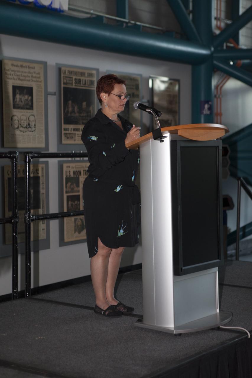 Inside the Apollo-Saturn V Center at the Kennedy Space Center Visitor Complex in Florida, Lisa May, with Murphian Systems, presents the Judges Innovation Award during the award ceremony for NASA's 8th Annual Robotic Mining Competition. More than 40 student teams from colleges and universities around the U.S. used their uniquely-designed mining robots to dig in a supersized sandbox filled with BP-1, or simulated Martian soil, and participated in other competition requirements, May 22-26, at the visitor complex. The Robotic Mining Competition is a NASA Human Exploration and Operations Mission Directorate project designed to encourage students in science, technology, engineering and math, or STEM fields. The project provides a competitive environment to foster innovative ideas and solutions that could be used on NASA's Journey to Mars. 