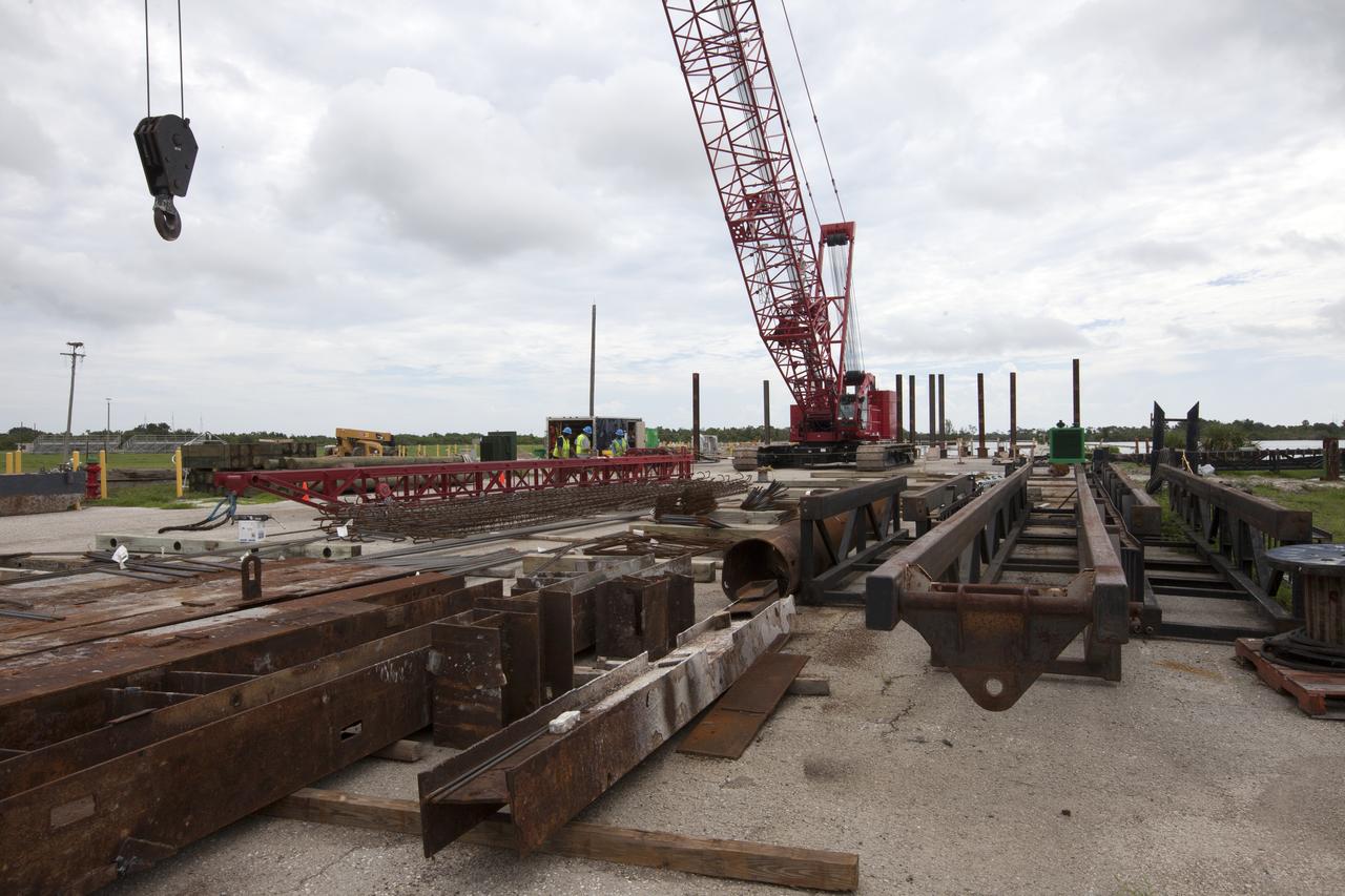 Modifications are underway at the Launch Complex 39 turn basin wharf at NASA's Kennedy Space Center in Florida to prepare for the arrival of the agency's massive Space Launch System (SLS) core stage aboard the barge Pegasus. Equipment is staged and a crane will be used to lift up precast concrete poles and position them to be driven to a depth of about 70 feet into the bedrock below the water around the turn basin. The upgrades are necessary to accommodate the increased weight of the core stage along with ground support and transportation equipment aboard the modified barge Pegasus. The Ground Systems Development and Operations Program is overseeing the upgrades to the turn basin wharf. 
