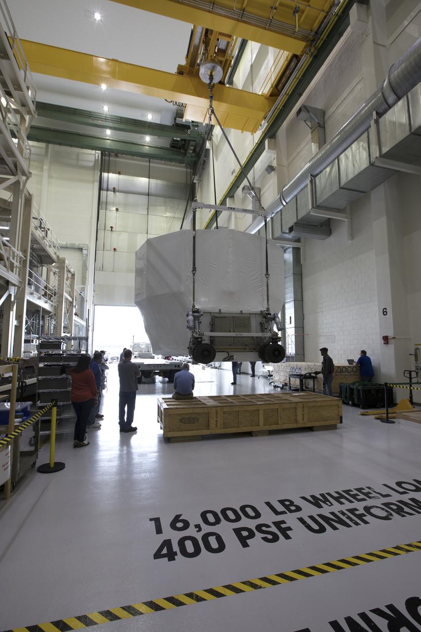 The Orion service module structural test article for Exploration Mission-1 (EM-1), built by the European Space Agency, is prepared for shipment to Lockheed Martin's Denver facility to undergo testing. Inside the Neil Armstrong Operations and Checkout Building high bay at NASA's Kennedy Space Center in Florida, a crane lifts the module, secured on a stand, for the move to the transport truck. The Orion spacecraft will launch atop the agency's Space Launch System rocket on EM-1 in 2019.
