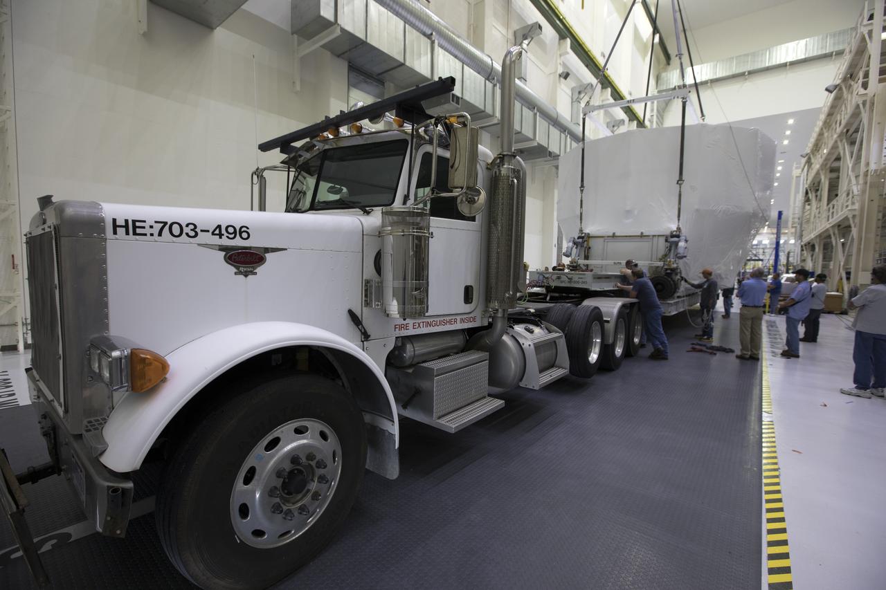 Inside the Neil Armstrong Operations and Checkout Building high bay, the Orion service module structural test article for Exploration Mission-1 (EM-1), built by the European Space Agency, is secured on the flatbed of a transport truck. The service module will be shipped to Lockheed Martin's Denver facility to undergo testing. The Orion spacecraft will launch atop the agency's Space Launch System rocket on EM-1 in 2019.