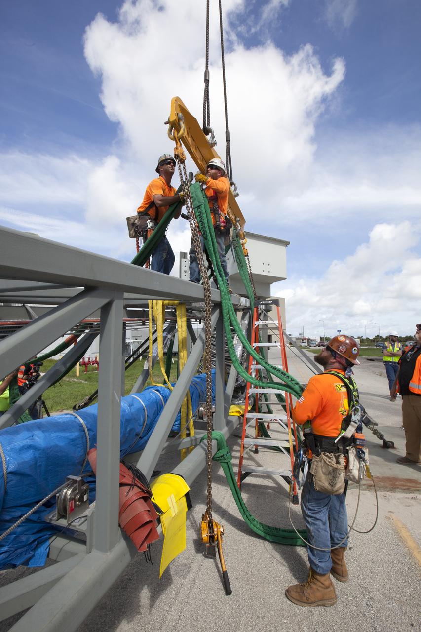 Just north of the Vehicle Assembly Building at NASA's Kennedy Space Center in Florida, technicians prepare a crane to lift the core stage forward skirt umbilical for installation onto the mobile launcher. The mobile launcher is designed to support the assembly, testing and check-out of the agency's Space Launch System (SLS) rocket and the Orion spacecraft.