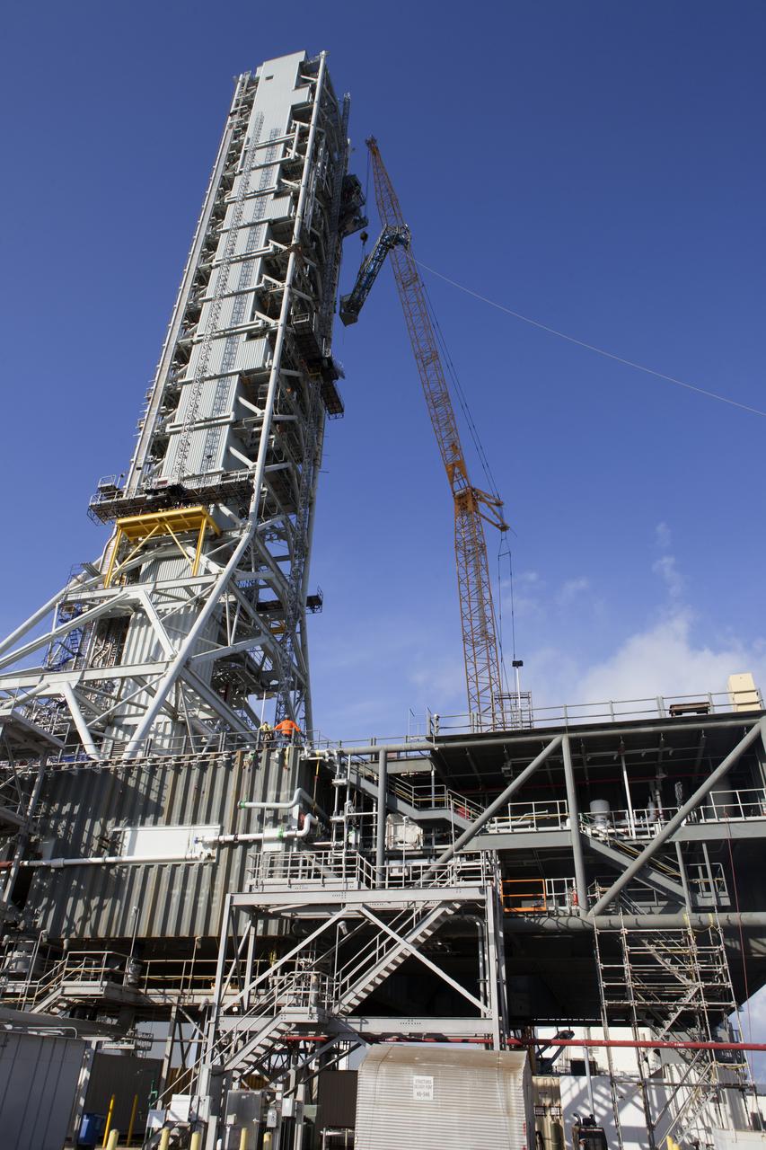 Just north of the Vehicle Assembly Building at NASA's Kennedy Space Center in Florida, a crane lifts the core stage forward skirt umbilical for installation onto the mobile launcher. The mobile launcher is designed to support the assembly, testing and check-out of the agency's Space Launch System (SLS) rocket and the Orion spacecraft.