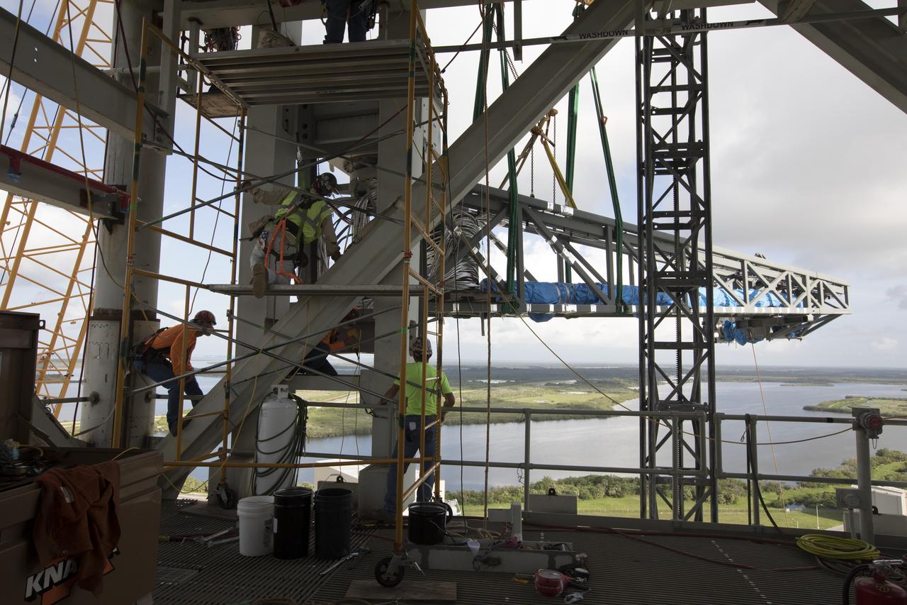 Just north of the Vehicle Assembly Building at NASA's Kennedy Space Center in Florida, technicians install the core stage forward skirt umbilical on the mobile launcher. The mobile launcher is designed to support the assembly, testing and check-out of the agency's Space Launch System (SLS) rocket and the Orion spacecraft.