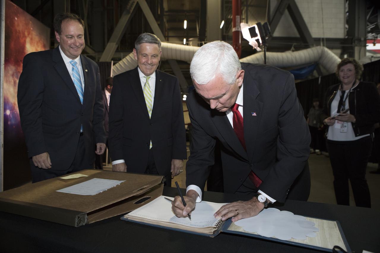 During his visit of NASA's Kennedy Space Center in Florida, Vice President Mike Pence signs a Kennedy Space Center guest book as the agency's Acting Administrator Robert Lightfoot, left, and Center Director Bob Cabana look on. During his visit to Kennedy, the Vice President spoke inside the iconic Vehicle Assembly Building, where he thanked employees for advancing American leadership in space. 