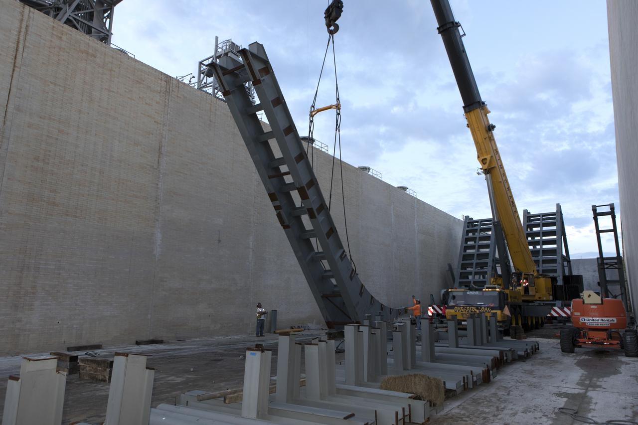 At Launch Pad 39B at NASA's Kennedy Space Center in Florida, a crane is used to move one of the large segments of the support hardware for a new flame deflector and position it in the flame trench. The new flame deflector will be positioned about six feet south of the shuttle-era flame deflector’s position. During liftoff of NASA’s Space Launch System, the rocket’s flame and energy will be diverted to the north side of the flame trench. The north side of the deflector will be protected by a NASA standard coating. The south side of the deflector will not be slanted and will have no lining. The new design will provide easier access for inspection, maintenance and repair. The Ground Systems Development and Operations (GSDO) Program at Kennedy is managing the installation of the flame deflector for Exploration Mission 1, deep space missions, and NASA's Journey to Mars.