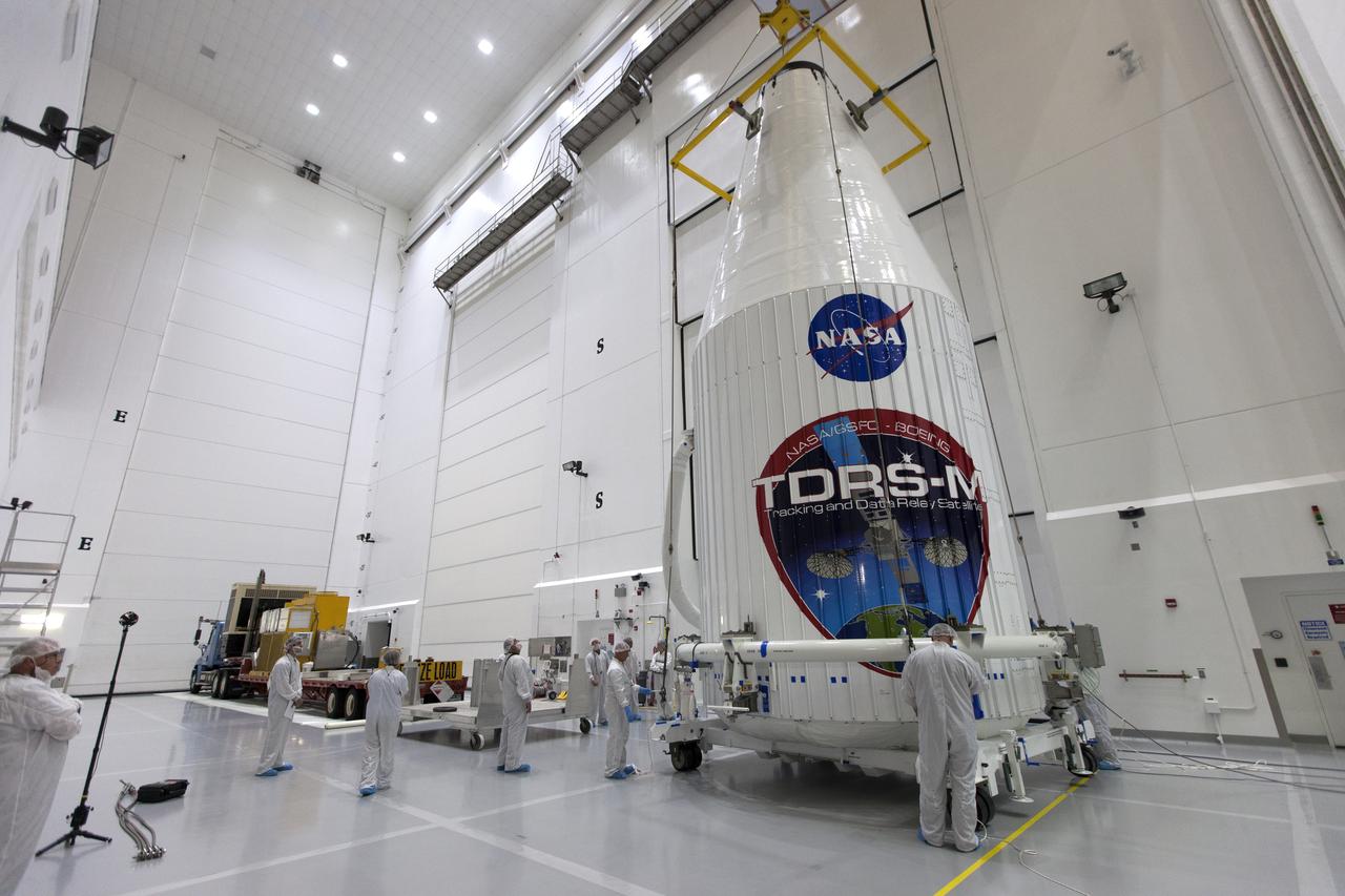 Inside the Astrotech facility near NASA's Kennedy Space Center in Florida, the agency's TDRS-M satellite, enclosed in its payload fairing, will be lifted by crane and lowered onto a transport vehicle. The TDRS-M is the latest spacecraft destined for the agency's constellation of communications satellites that allows nearly continuous contact with orbiting spacecraft ranging from the International Space Station and Hubble Space Telescope to the array of scientific observatories. Liftoff atop a United Launch Alliance Atlas V rocket is scheduled to take place from Space Launch Complex 41 at Cape Canaveral Air Force Station on Aug. 18 at 8:03 a.m. EDT.
